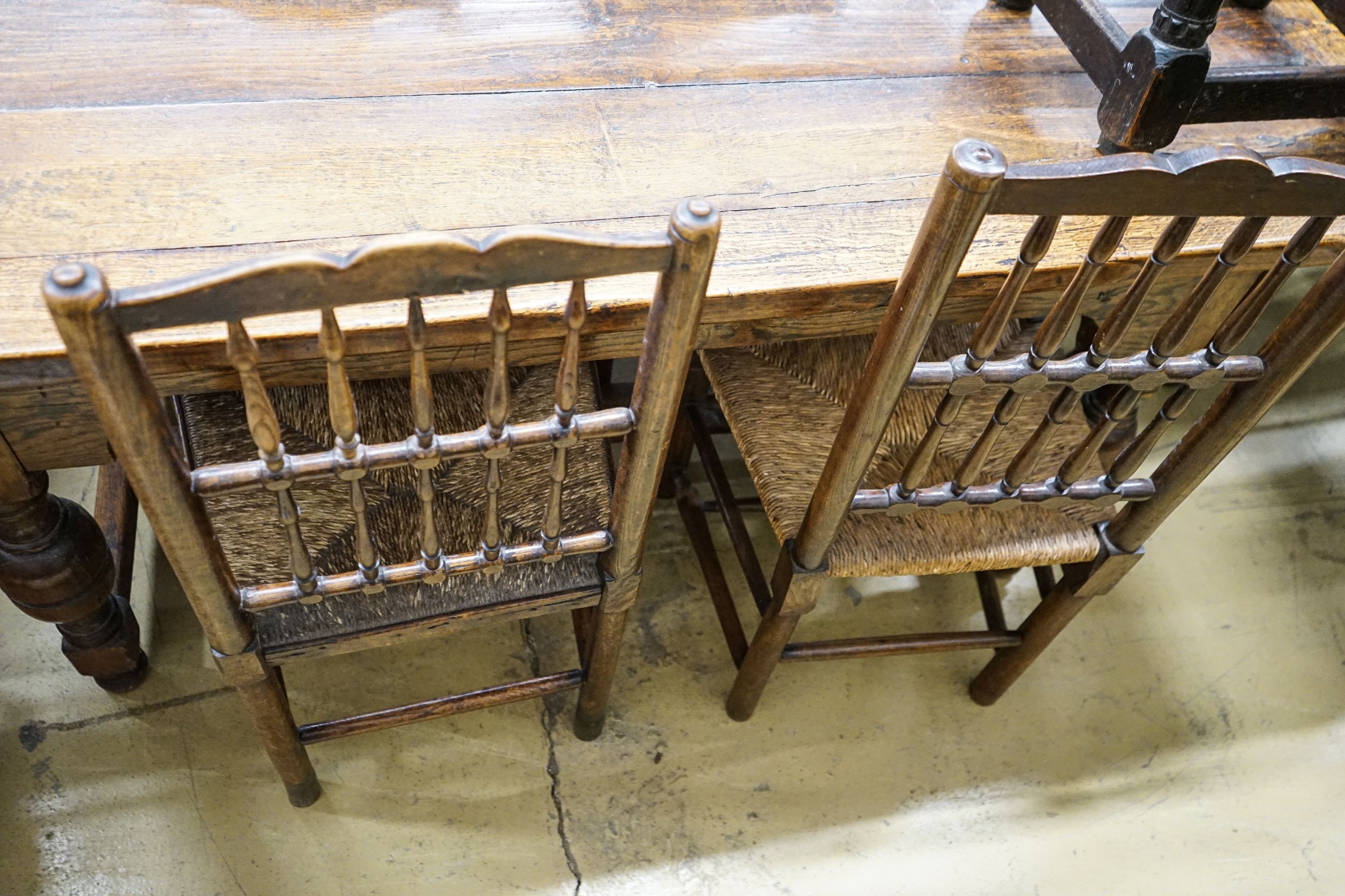 A harlequin set of five oak, elm and beech spindle back chairs, with rush seats and a similar ladderback carver